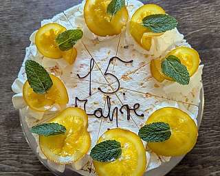 Sahnetorte mit Orangenscheiben und Aufschrift 15 Jahre