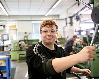 Junger Mann in Metallwerkstatt