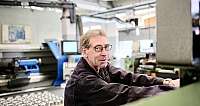 Ein Techniker bedient eine CNC-Drehmaschine in einer Werkstatt.