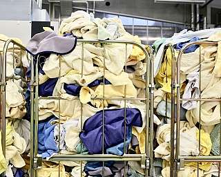 Viele frische Wäschestücke in Rollwagen