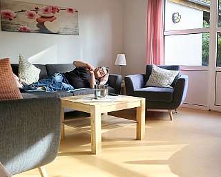 Lächelnder Mann liegt gemütlich auf einem Sofa
