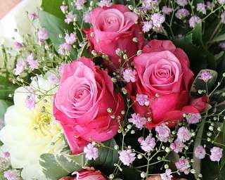 Ein Bouquet mit rosa Rosen und kleinen Blüten.
